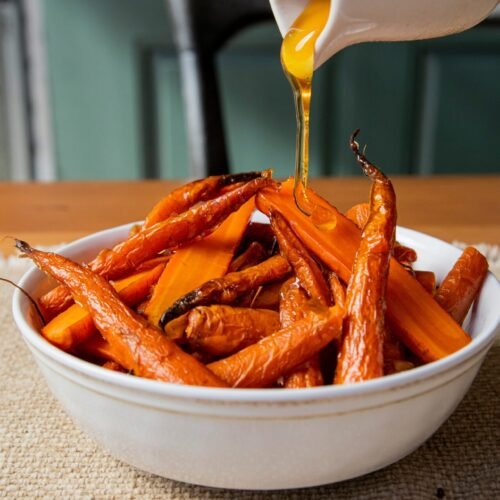 a white bowl filled with carrots sitting on top of a table